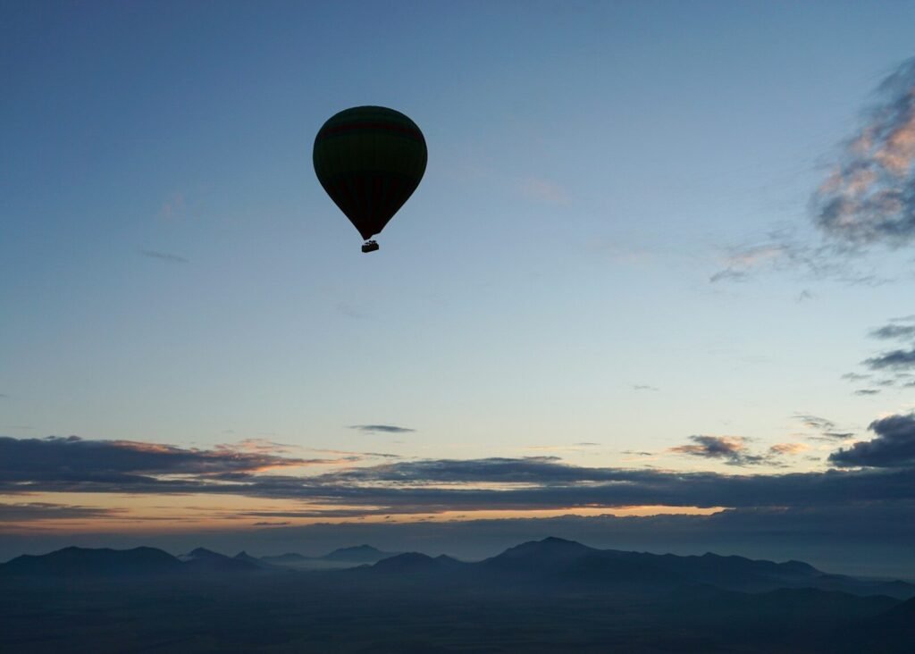 a hot air balloon flying over a mountain range
