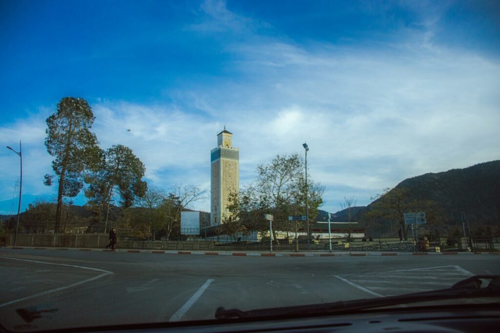 A view of a parking lot with a clock tower in the background
