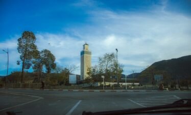 A view of a parking lot with a clock tower in the background