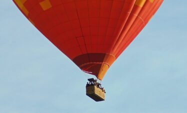 a large hot air balloon flying through a blue sky