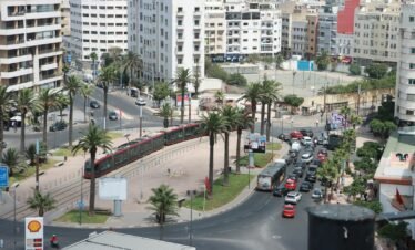 A city street filled with lots of traffic next to tall buildings