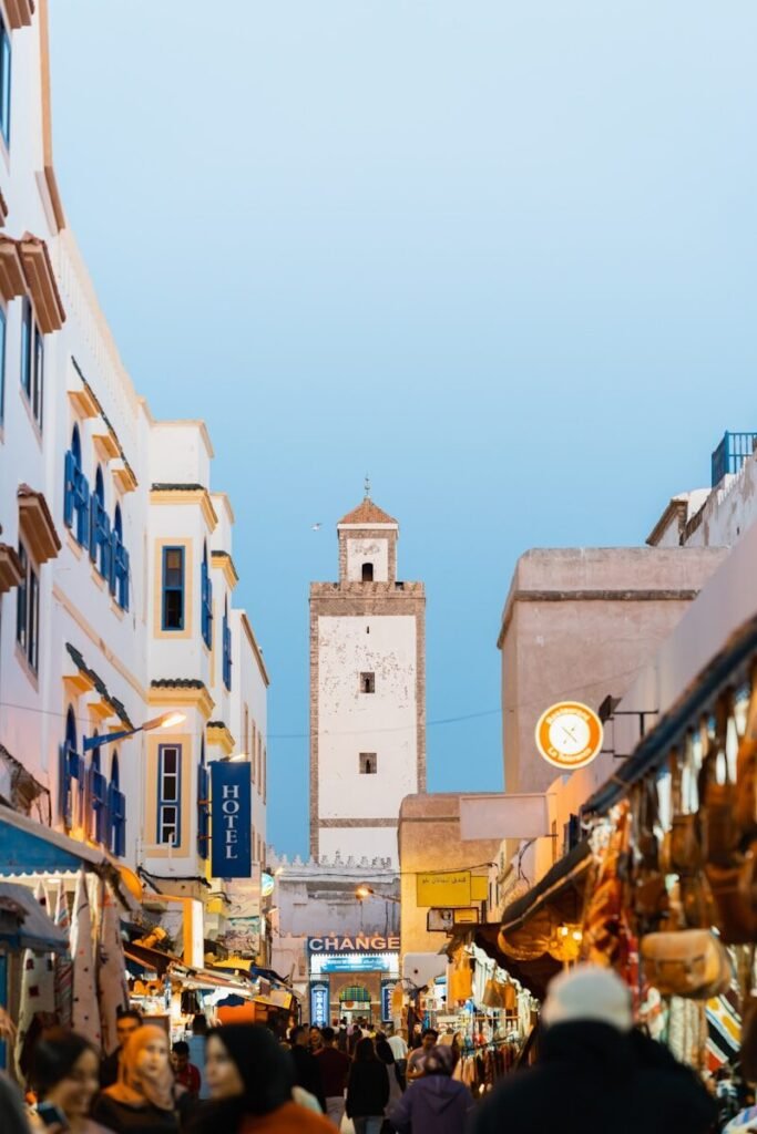 a group of people walking down a street next to tall buildings